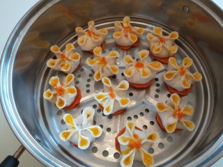 20、蛋液灌饺  新文美食,蒸锅铺上12个胡萝卜片，放上蒸饺。