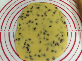 11、葡萄干奶酥,把面团放在案板上压扁,用擀面杖擀成厚约0.8厘米的面片。