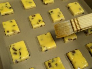 14、葡萄干奶酥,用刷子在表面刷一层蛋黄液。