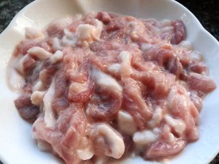 2、京酱肉丝,猪肉切成丝打入蛋清倒入料酒、糖、淀粉搅拌均匀煨制10分钟