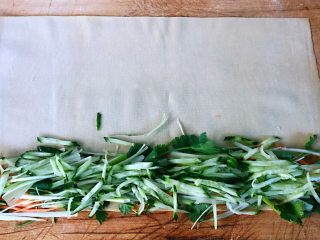 4、京酱肉丝,豆皮平铺在菜板上切好的胡萝卜、黄瓜、香菜、葱均匀的摆在豆皮的一侧