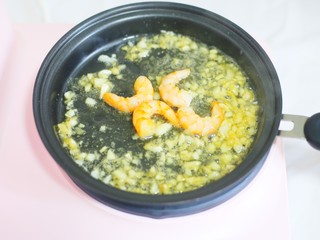 4、十分钟营养早餐面,多功能早餐机炒锅烧热加油，加入剩余的大蒜爆香，加入虾仁炒香。