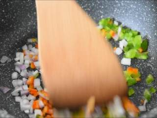 6、外皮干香不腻，内心鲜嫩可口，多吃一点也没压力的蒜香骨,锅中入蔬菜丁，炒匀。