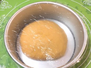 14、胡萝卜吐司面包,整理滚圆，面团放入模具，盖上保鲜膜。
