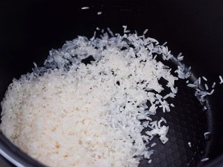 6、干贝排骨粥,把浸泡好的大米捞出放入高压锅胆内