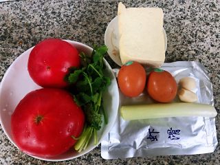 1、虾滑番茄豆腐蛋花羹,准备原材料虾滑、番茄、鸡蛋、豆腐、葱、香菜、蒜备用