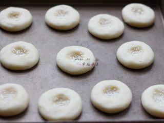 6、老式桃酥,步骤5的面糊分为12份，每份25～30g左右，搓圆按扁，中间按压至2/3深，然后撒适量白芝麻在中间凹陷处（注意每个生坯间的摆放间距，烘烤过程中将会膨胀开，图中我摆放的已经过密了，烘烤后有部分粘连了～）