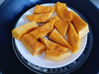 3、南瓜麻球,再切块,隔水蒸熟,可以用筷子扎一下来辨别是否蒸熟,轻松扎透即为熟透。