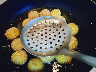 10、南瓜麻球,炸至麻球全部飘起来,用漏勺轻轻按麻球,反复多次按压,麻球明显的变大,继续小火炸至两面金黄即可捞出。