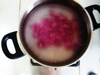 2、紫薯山药粥,把切好的紫薯和米一起淘洗后，放在燃气灶上，煮粥时水可以稍微多一些，因为紫薯比较难煮，水太少容易煮干，