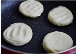 15、油旋,小火烙，并时不时的用锅铲压一压饼坯，烙至饼坯两面金黄即可。