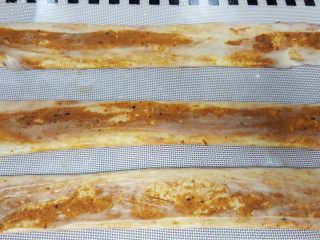 11、油旋儿,11．用手将饼胚压扁，压扁后用擀面杖擀长，用手捏住两边再抻长。