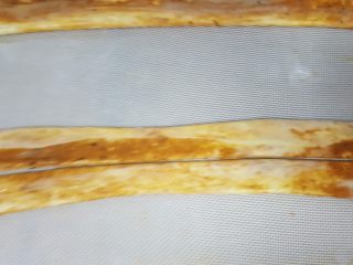 12、油旋儿,12．取一个饼胚从中间用刮刀切开。