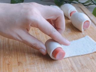 4、香肠飞饼卷,放上小香肠，从尖端的一头卷起