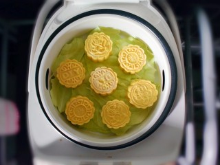 25、紫薯南瓜糯米糕,放在蒸锅上蒸。为了防黏，我在底下垫了一层菜叶子。