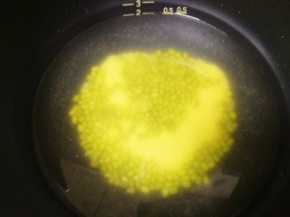 7、绿豆小米粥,和绿豆一起放入电饭煲锅胆内，加入适量的水。（一共半盒米，水位放到0.5的位置）