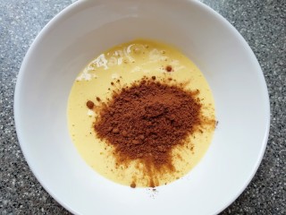 5、双色甜甜圈,取50g翻拌好的蛋糊出来，加入可可粉翻拌均匀。