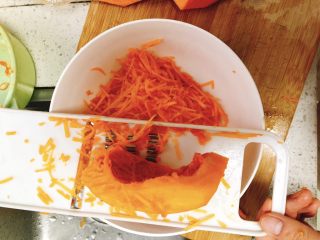 4、咸味南瓜饼,用刨皮器将南瓜刨成丝。