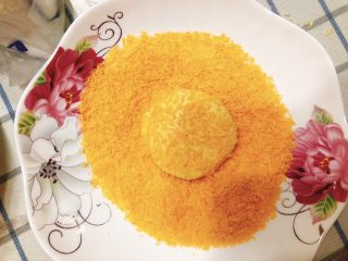 15、咸味南瓜饼,另取一个盘子，倒入一饭碗的面包糠，将南瓜饼放到面包糠里滚一圈，使南瓜饼粘满面包糠。