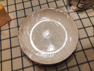 16、咸味南瓜饼,取一个空盘子，包上保鲜膜。（若量做的大，不是一次性吃完的话一定要在碗里包一层保鲜膜，否则冷冻后南瓜饼无法脱盘）