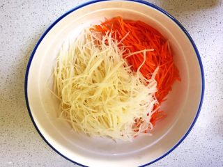5、时蔬鹌鹑蛋早餐饼,把土豆丝和胡萝卜丝放入大碗里