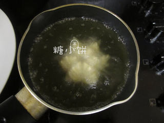 15、莲花酥,最后花瓣全部打开，这时可以调整一下火候，因为一直加热的话油温会偏高