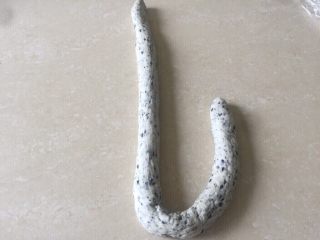 16、佛系养生黑芝麻辫子面包,第十六步：搓长后取一根面团先放成L形