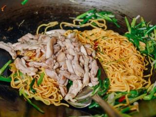 6、姜葱面, 加入鸡肉，翻炒，可以加一点热水。