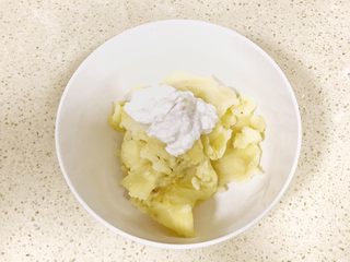 9、甜美的下午茶之蓝莓土豆球,加入适量的酸奶，搅拌均匀，这个过程中，要根据土豆泥的厚薄，调整酸奶量，如果太醇厚，口感会硬，需要再加入酸奶