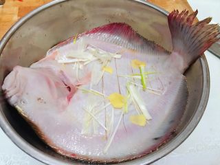 4、清蒸多宝鱼,上下两面放上葱姜煨制20分钟入味