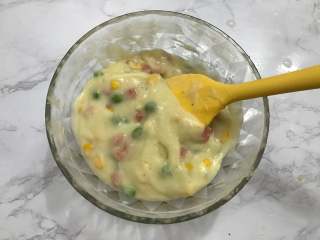 5、芝士焗土豆泥,把处理好的玉米粒、豌豆、火腿丁倒入土豆泥中,搅拌均匀。