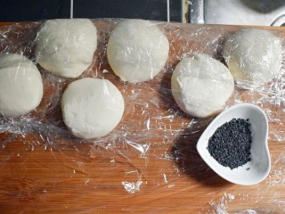 12、紫薯烧饼,将醒发好的面复揉成光滑的面团后，根据紫薯丸子的数量，将面团分成相同数量的面剂子，并准备适量的黑芝麻。