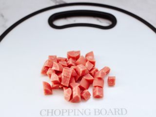 3、青口火腿青菜粥,火腿肠去掉外皮后,用刀切成小丁。