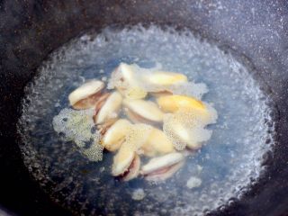 5、青口火腿青菜粥,锅中倒入适量清水煮沸后,倒入料酒和适量的盐,把解冻后的青口肉焯一下水,捞出沥干水分。