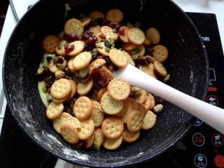 7、好吃到流眼泪的网红雪花酥,7.加入混合好的饼干然后关火开始用刮刀快速的上下翻拌让棉花糖尽量裹上去