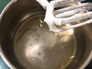 7、双色戚风蛋糕,玉米油和清水混合，加入盐和细砂糖10克，用打蛋器低速搅拌至混合。