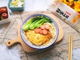 9、煎蛋早餐面,将面条盛入碗里，放上煎蛋，摆上小青菜和火腿肠片，浇上汤汁。 