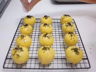 4、蛋黄酥,沙上芝麻，烤箱预热160度，包好的蛋黄酥放烤箱中层，烤25分钟