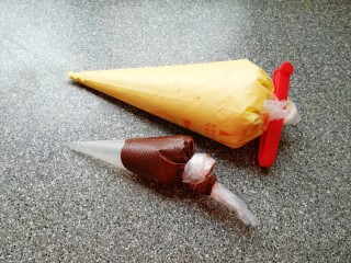 6、双色甜甜圈,原味蛋糊和可可蛋糊分别装入裱花袋。 烤箱上下管165度预热。