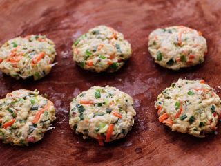 11、槐花胡萝卜鸡蛋饼,把搅拌均匀的槐花面团，用手先揉均匀后，再用手摁扁，依次做完所有的槐花饼。