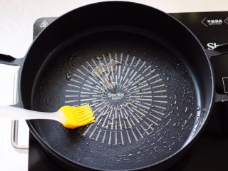 12、槐花胡萝卜鸡蛋饼,煎锅烧热后，用刷子蘸花生油把煎锅刷上一层薄薄的油。