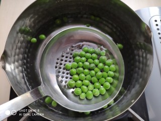 2、火腿豌豆蛋炒饭,锅里放水煮开,将剥好的豌豆焯熟。