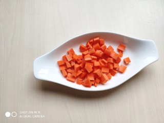 4、火腿豌豆蛋炒饭,胡萝卜切成小丁后焯水。