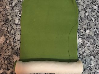 8、雙色抹茶饅頭,白麵糰上刷點水，放上抹茶麵糰，稍微桿ㄧ下，就可以捲成圓筒狀，並稍為滾ㄧ下，讓結合線那面朝下。
