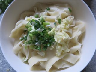 12、教你做一碗销魂的油泼面,开锅后煮大概1分钟左右，捞起面片看似透明就煮熟了，捞入大碗内，在面上面放入葱和蒜碎