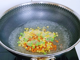 2、小熊便当套餐,将胡萝卜丁，玉米粒，豌豆粒焯水，水开后下锅，大火煮1分钟捞出淋干水分备用。