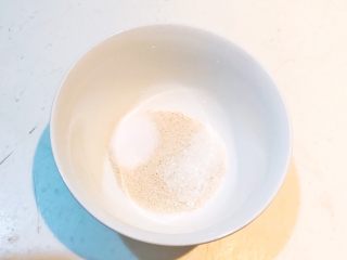 1、自制健康油条,把酵母粉放入碗里，加入白砂糖和精盐