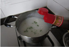 7、生滚鱼片粥,关火，撒上葱花；撒上适量胡椒粉；最后点入香油，即可。