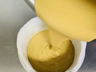 9、红糖马拉糕,将模具边缘贴上油纸方便脱模，将搅拌好的面糊倒入模具中。