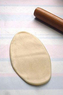 6、最接地气的鲜肉月饼,擀薄成长圆形，卷起。擀的时候，用力越轻越好，过重会将薄薄的酥皮擀破。